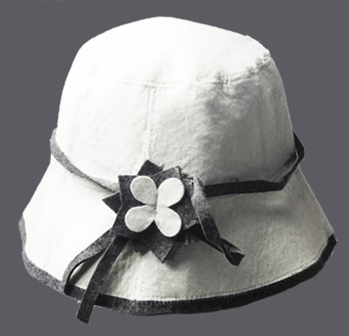 A natural white cloche hat with a flower decoration on it.