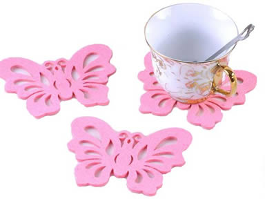 Three pink butterfly shaped wool felt coasters with a cup on the one coaster.