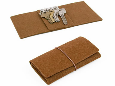 An unfolded felt key holder with several keys in it and a folded felt key holder.