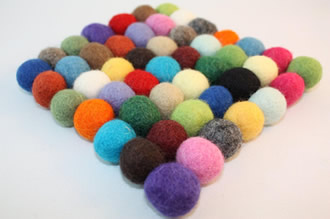Various colors of wool felt balls are put together to form a diamond shape.