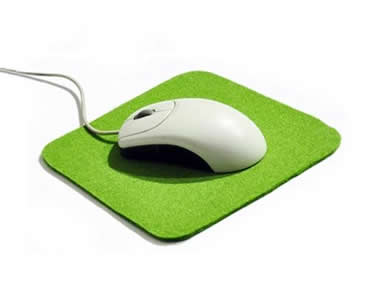 A white and black mouse on the green mouse pad.