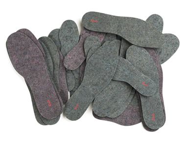 Several pairs of wool felt insoles with our company name on it.