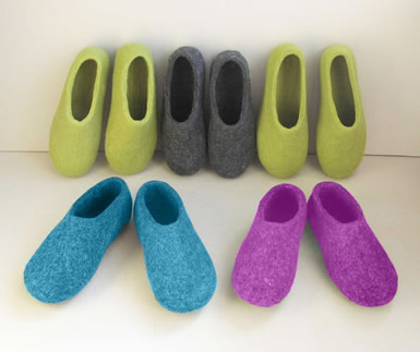 Five pairs of closed slippers on the white paperboard.